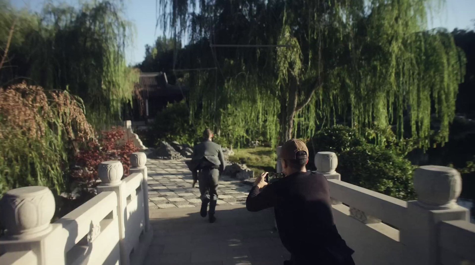 a woman taking a picture of a man on a bridge