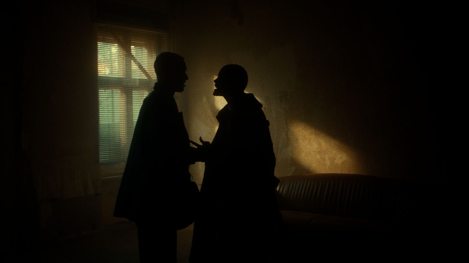 a couple of men standing next to each other in a dark room