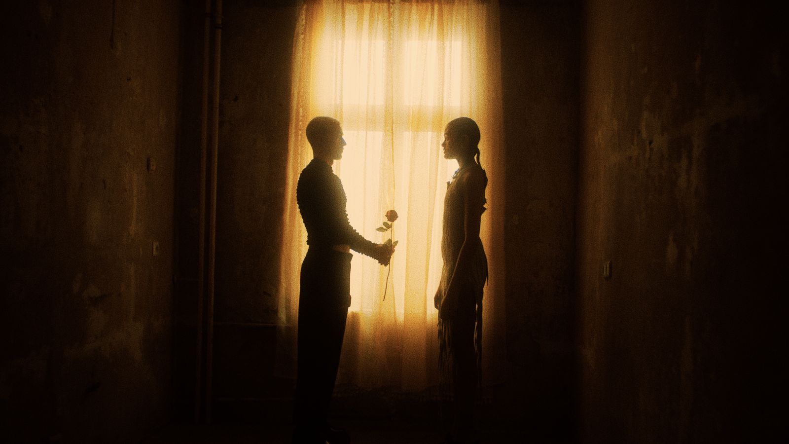 a man and a woman standing in front of a window