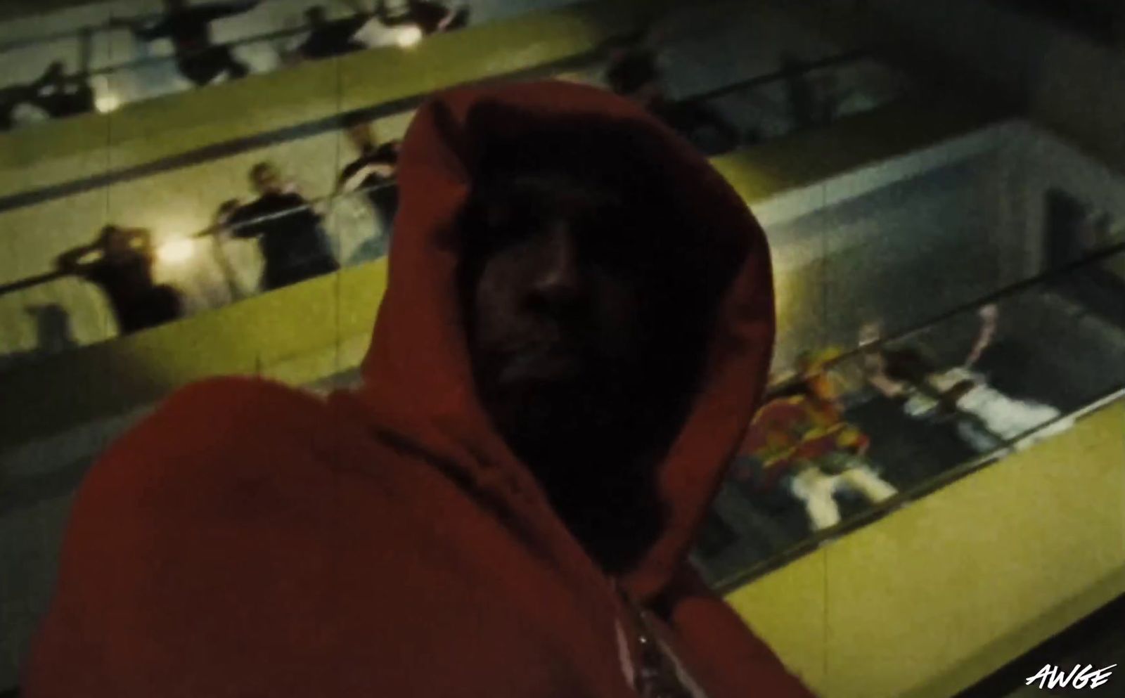 a man in a red hoodie standing in a auditorium