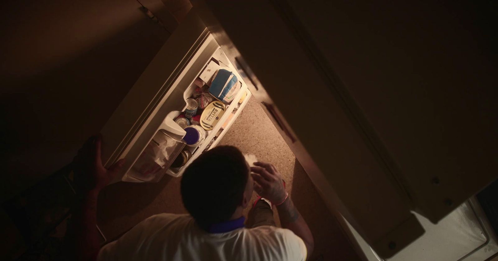 a man standing in front of an open refrigerator