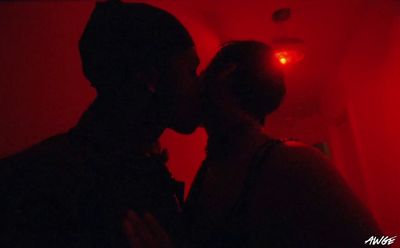 a man and a woman kissing in a dark room