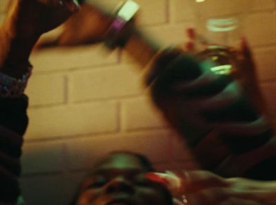 a group of people holding up drinks in front of a brick wall