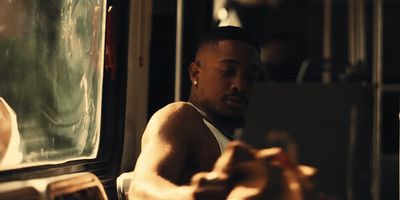 a man sitting on a bus looking at his cell phone