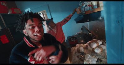 a man with dreadlocks standing in a kitchen