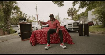 a man sitting on a bed in the middle of a street