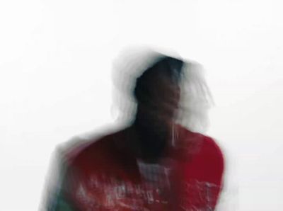 a blurry image of a man in a red shirt