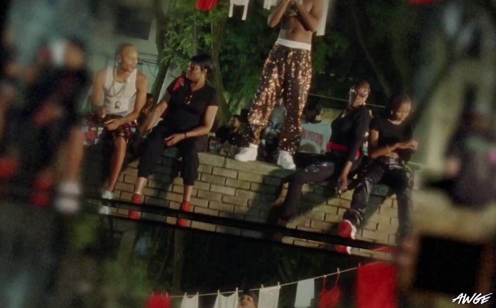 a group of people sitting on top of a brick wall