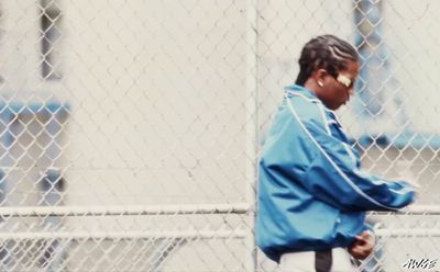 a woman standing in front of a chain link fence