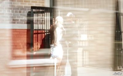 a blurry photo of a woman standing in front of a brick building