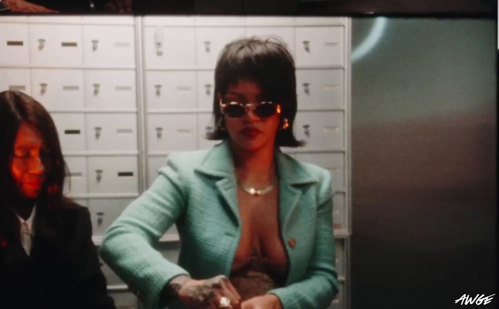 a woman in a suit and sunglasses standing in front of a locker