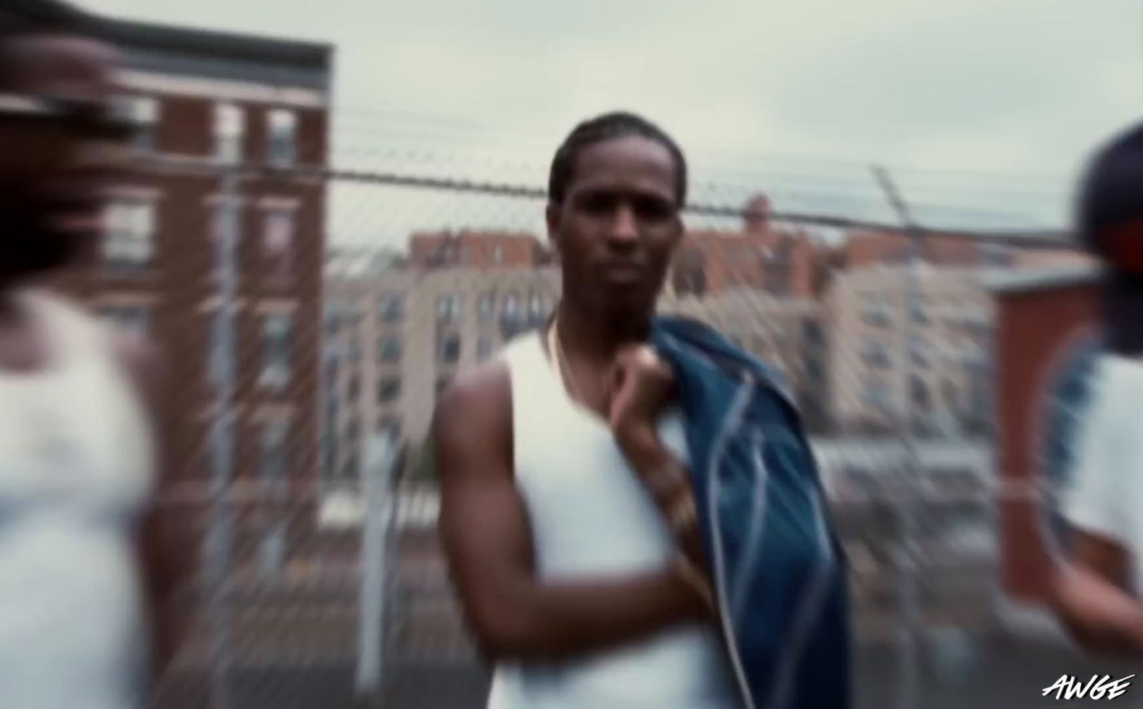 a man in a white tank top is holding a blue tie