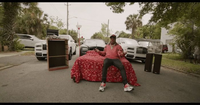 a man sitting on top of a bed in a parking lot