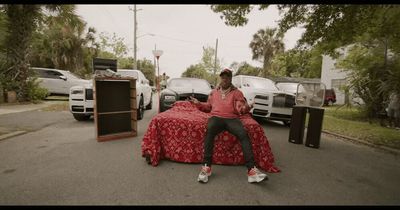 a man sitting on top of a bed in a parking lot