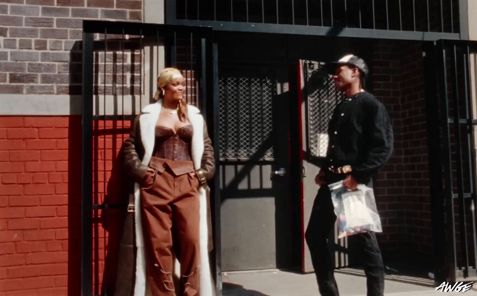 a man and a woman standing in front of a gate