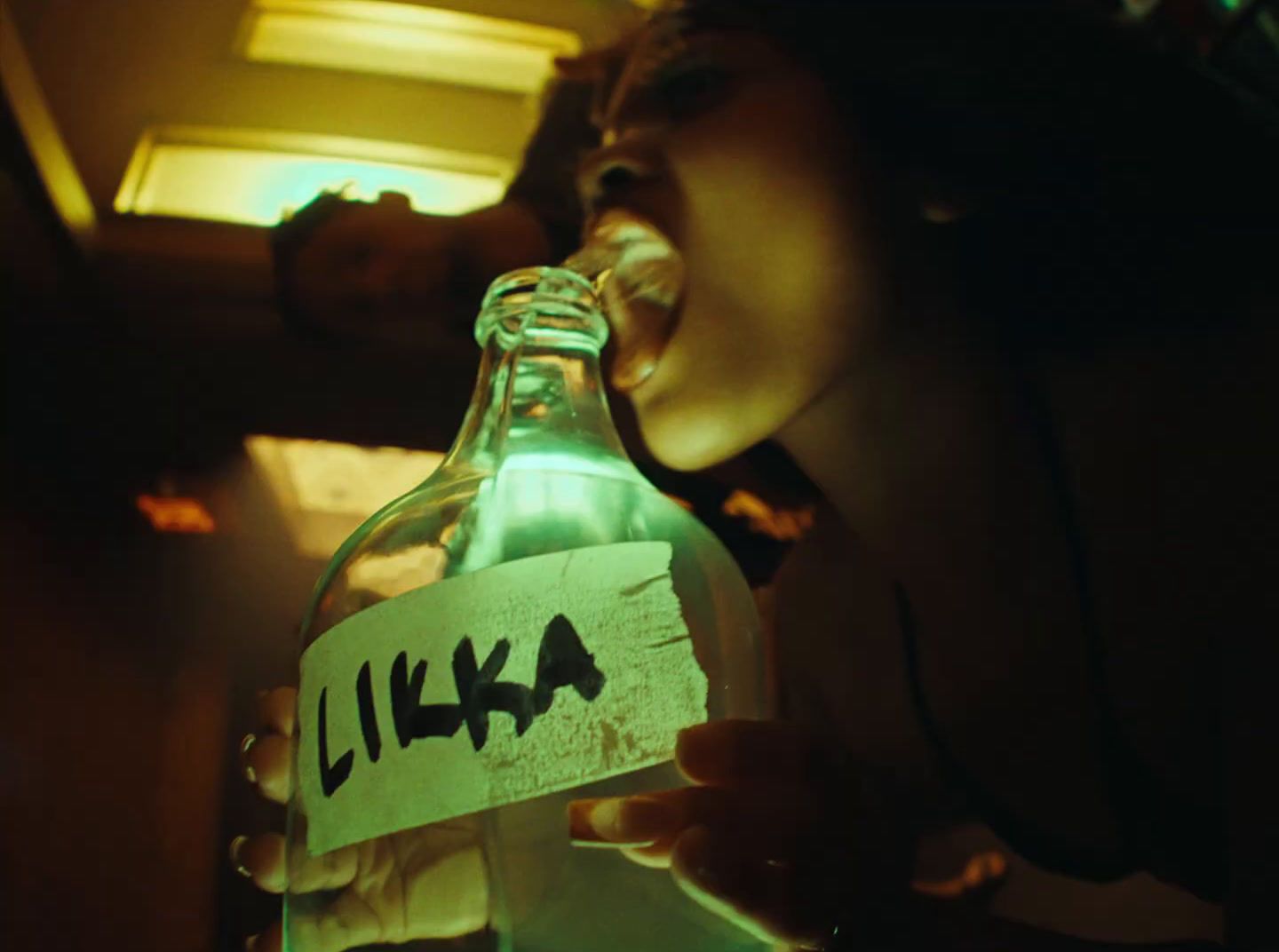 a person opening a bottle with a lit up label on it