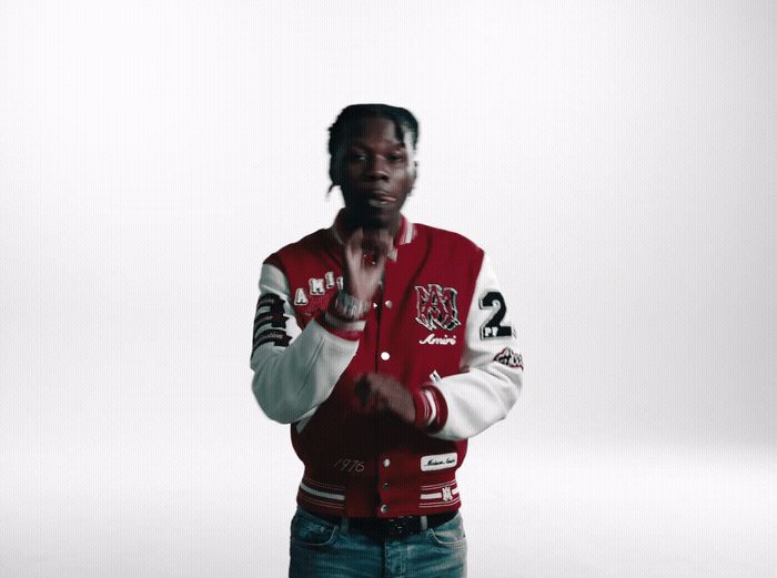 a man in a red and white jacket standing in front of a white background