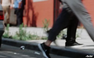 a person walking across a street next to a car