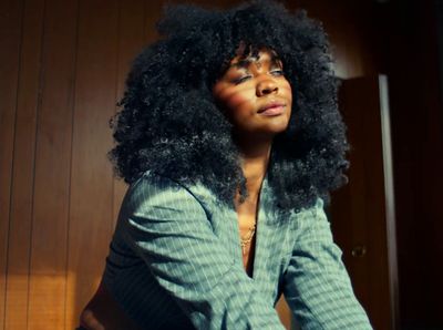 a woman with an afro sitting on a chair