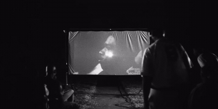 a group of people watching a movie on a large screen