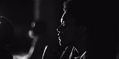 a black and white photo of a man in a dark room