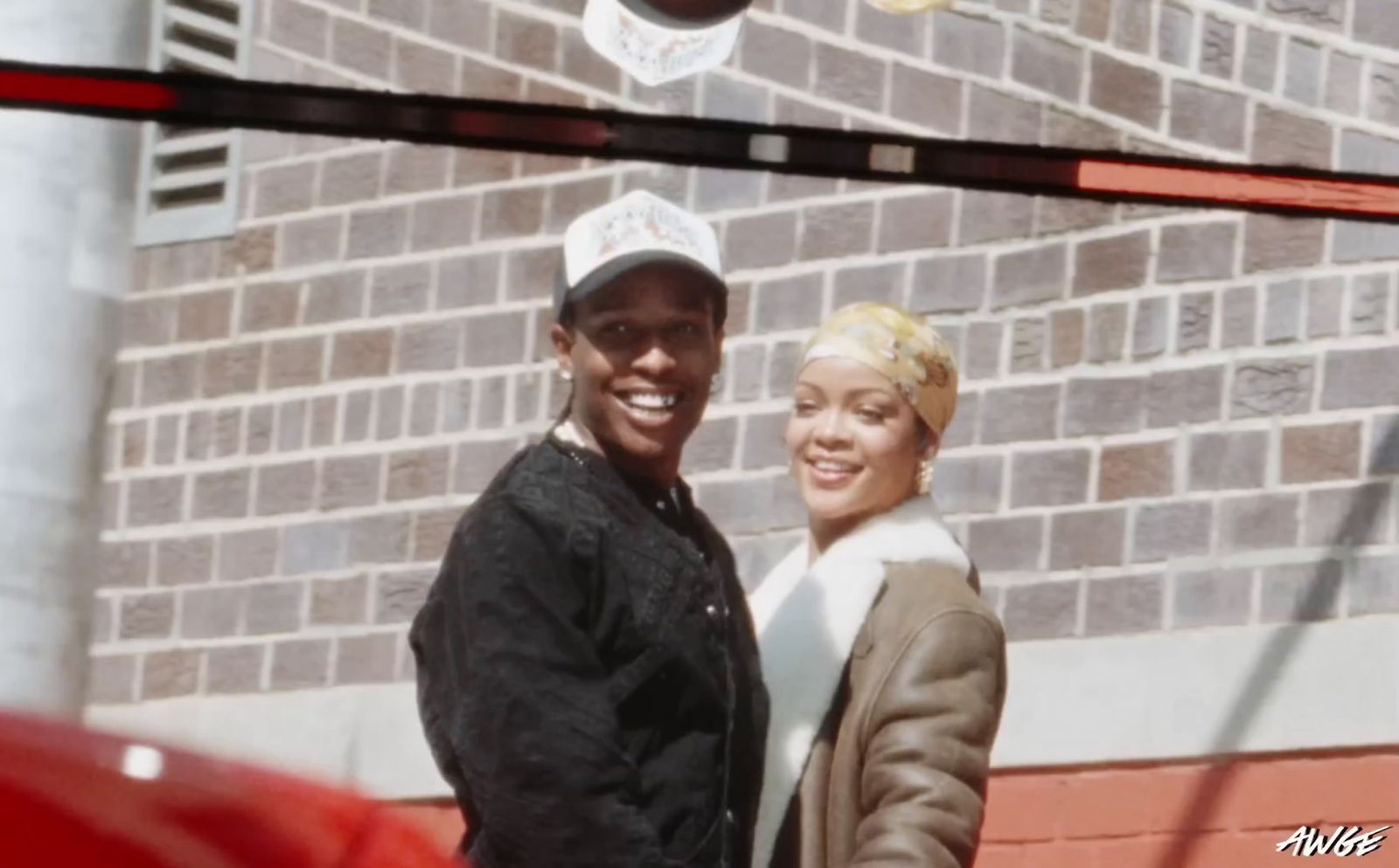 a man and a woman standing in front of a brick building