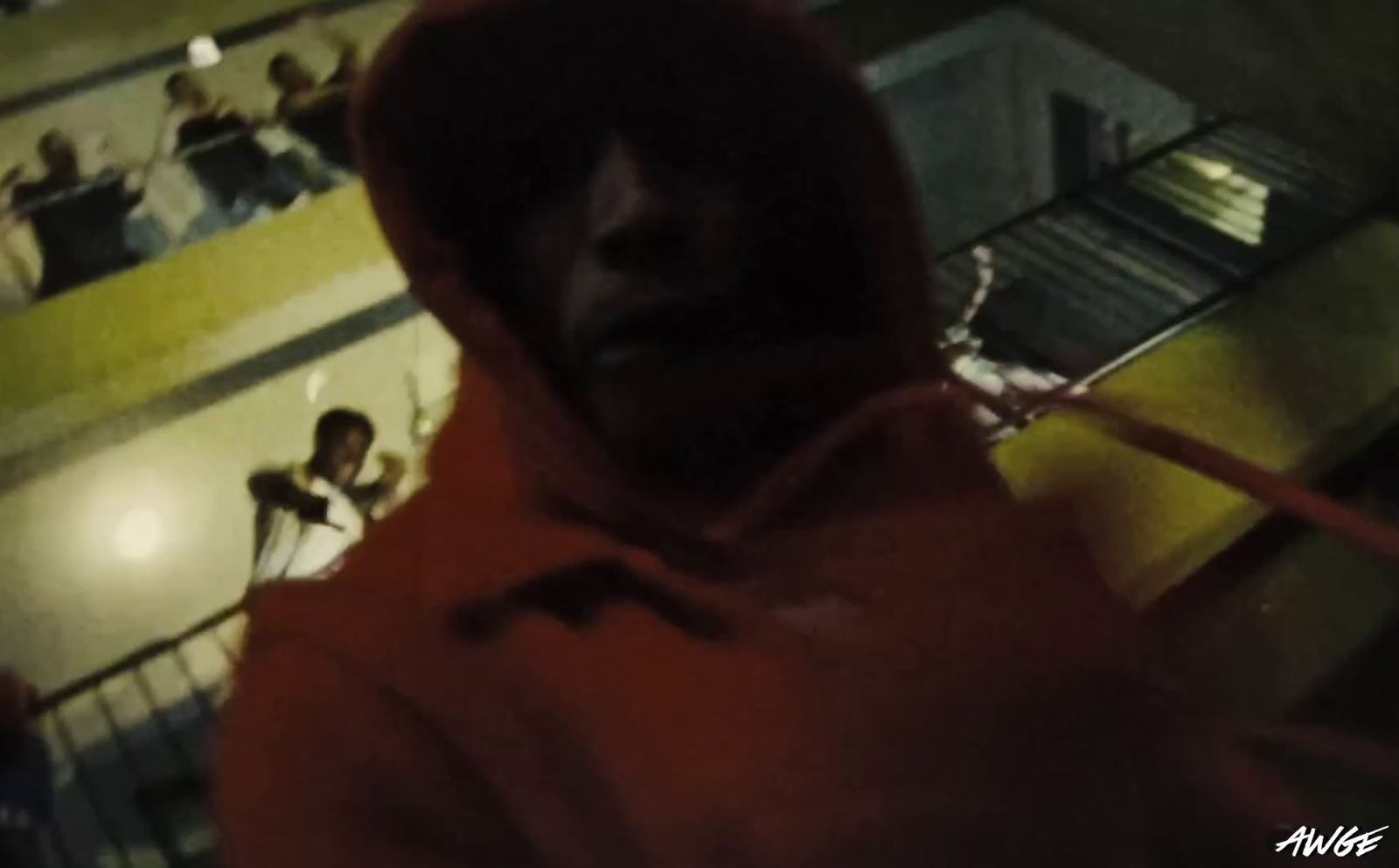 a man in a red hoodie standing in front of a group of people