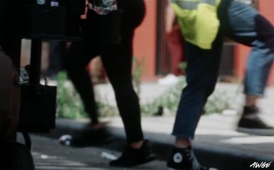 a group of people walking down a street next to a building