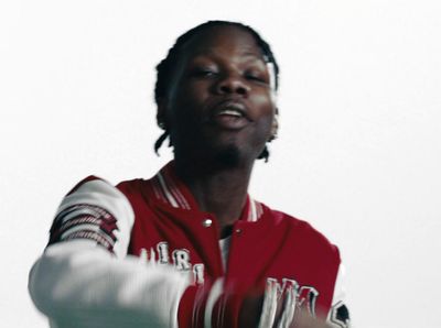 a man in a red and white baseball jacket holding a bat