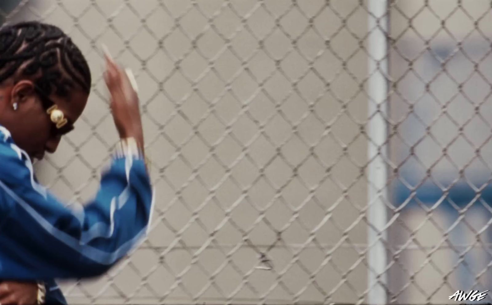 a woman standing in front of a chain link fence