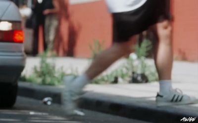 a man riding a skateboard down a street next to a car