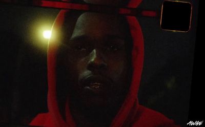 a man in a red hoodie stares into a mirror