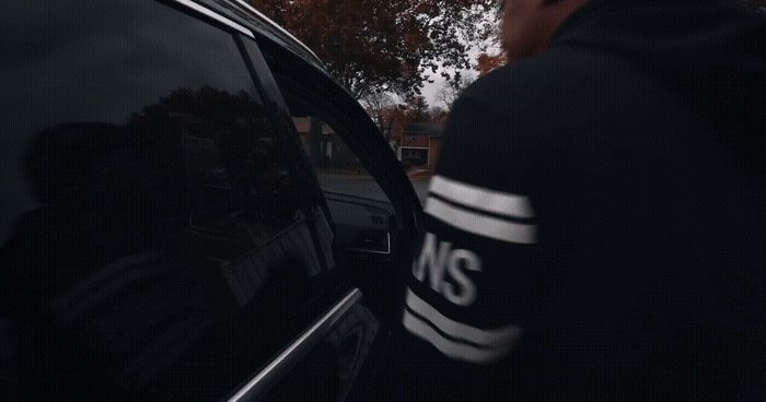 a man standing next to a parked car