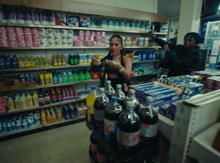 a woman standing in front of a store filled with drinks