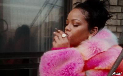 a woman in a pink fur coat smoking a cigarette