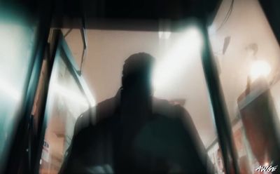 a blurry image of a man walking down a hallway