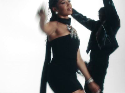 a woman in a black dress dancing with a man in a black suit