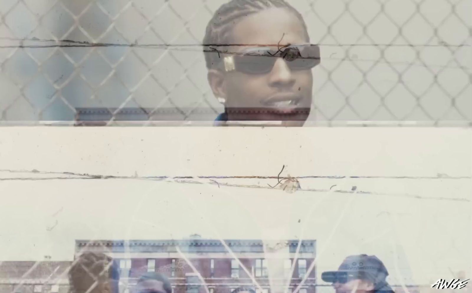 a woman wearing sunglasses behind a chain link fence