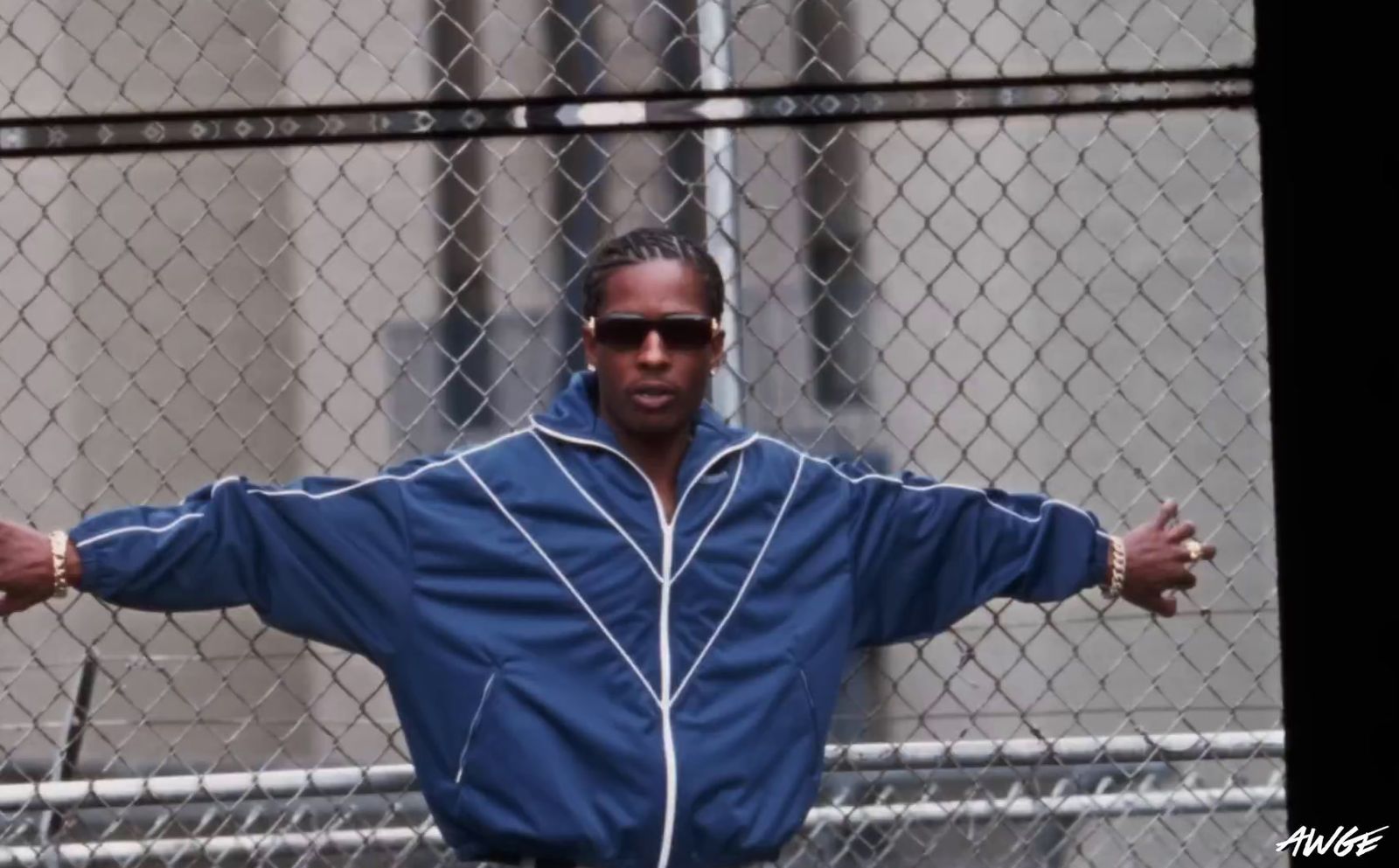 a man standing in front of a chain link fence