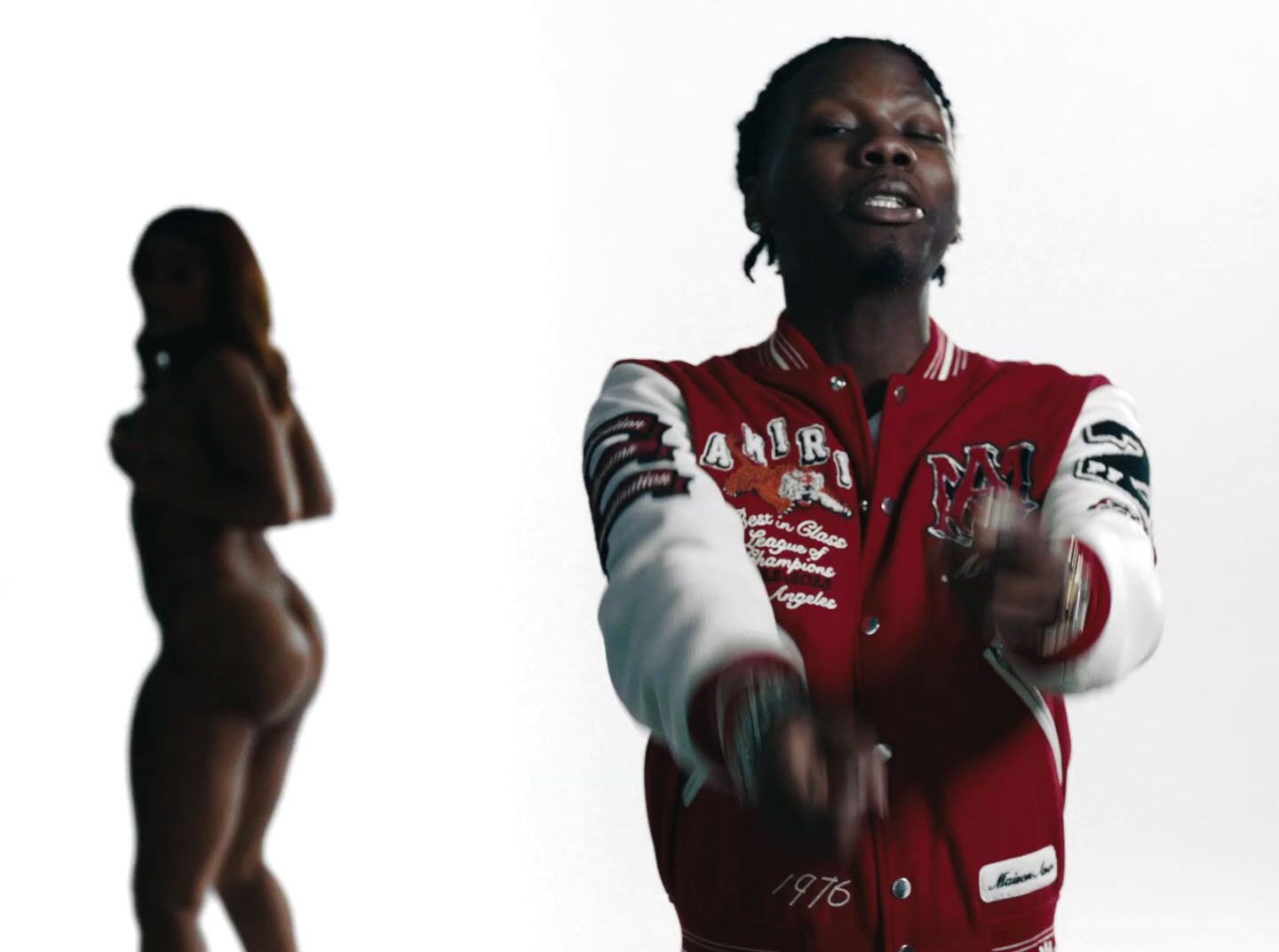 a woman in a red and white jacket next to a mannequin