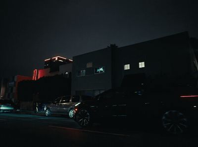 cars parked in front of a building at night