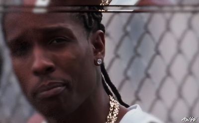 a close up of a person behind a chain link fence