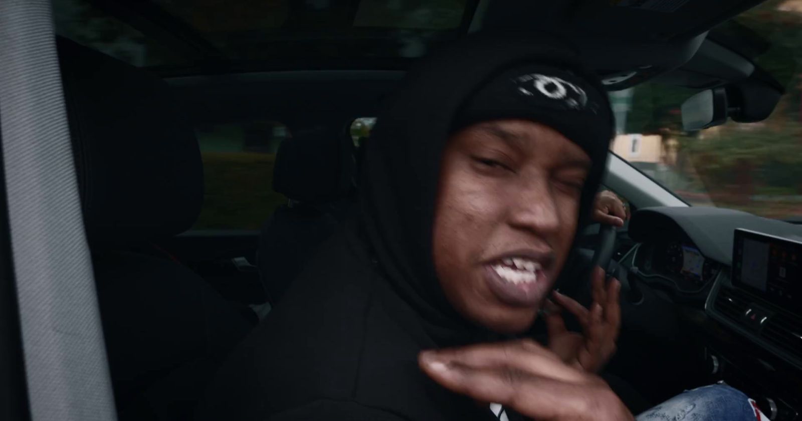 a man sitting in a car talking on a cell phone