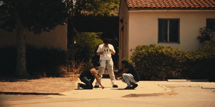 a group of people sitting on the ground in front of a house