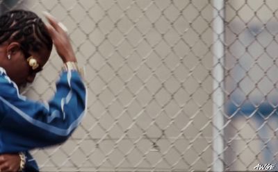 a woman standing in front of a chain link fence