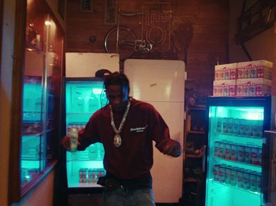 a man standing in front of a refrigerator filled with drinks