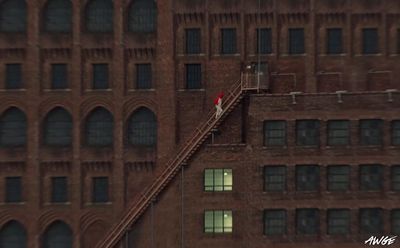 a person walking up a set of stairs in front of a brick building