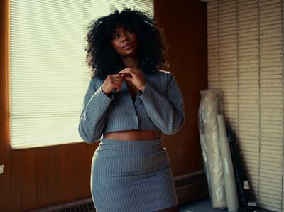 a woman standing in front of a window in a room