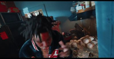 a man with dreadlocks standing in a kitchen