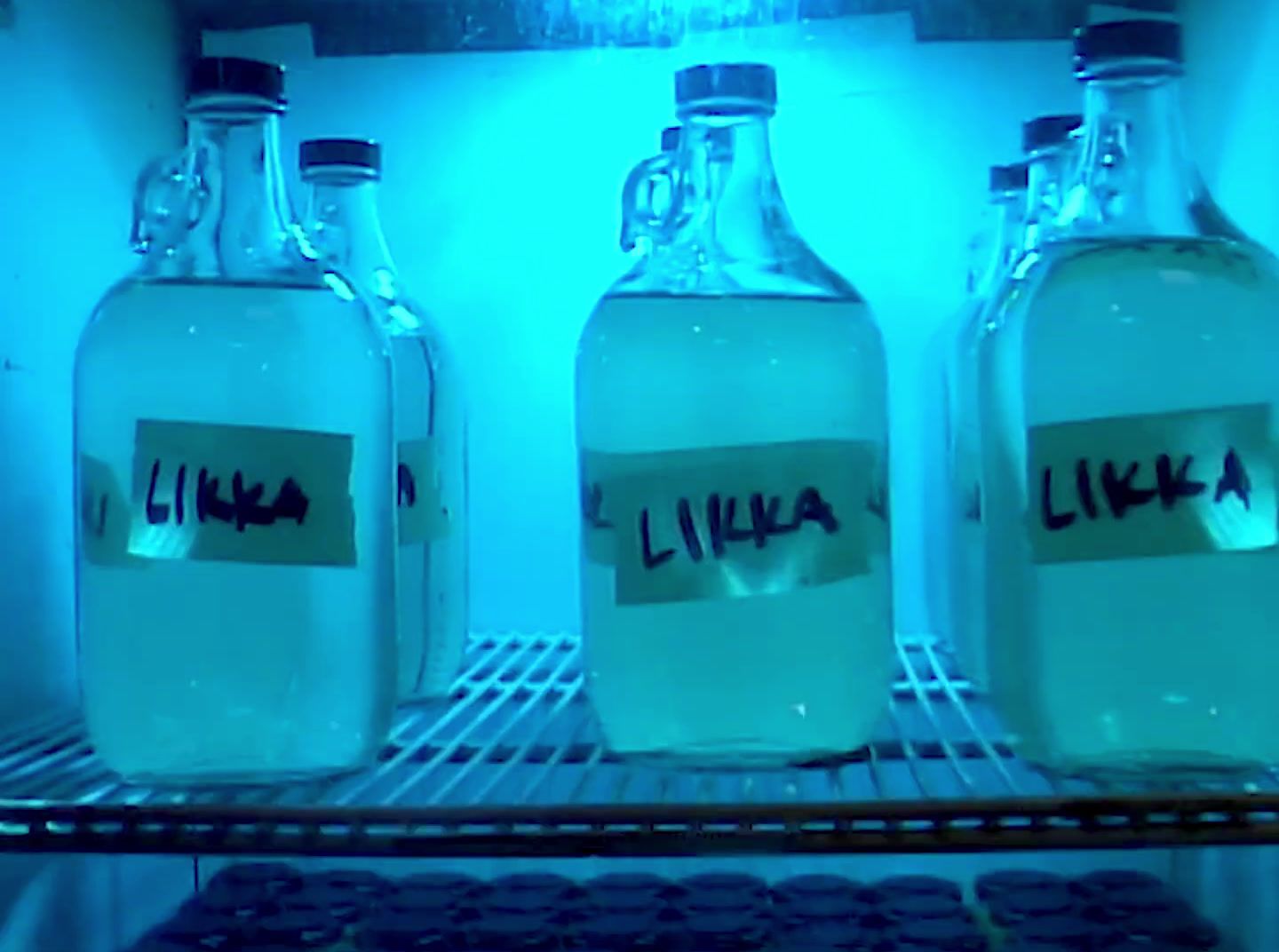 three bottles of water are sitting on a shelf